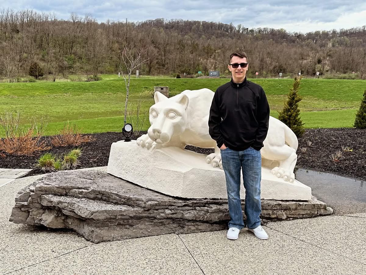 Photo of Cole Fetterman standing next to the Penn State LHV Statue